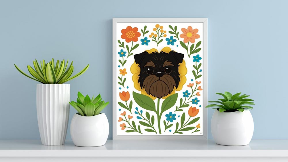 Framed Brussels Griffon floral art print displayed on a white shelf, surrounded by modern white planters with green succulents, against a soft blue wall