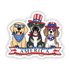 Sticker of three dogs - a Yellow Lab wearing a blue and white star bandana, a brown and tan mutt wearing a red, white, and blue USA flag top hat, and a brown and white Beagle wearing a red, white, and blue USA flag top hat and blue and white star bandana. A red, white, and blue banner with text 'America' is below the dogs.