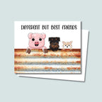Different But Best Friends greeting card featuring a cute pig, a black and tan Brussels Griffon, and a tan cat peeking over a rustic tin fence, text above animals is "Different But Best Friends" and is in a fun text with mix of capital and lower-case letters, card has a white background