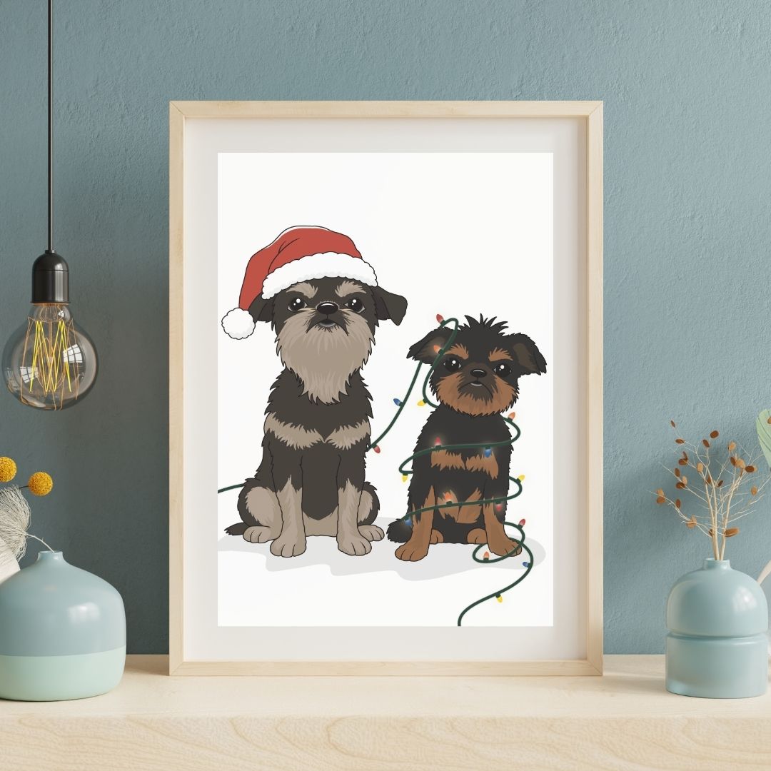 Framed custom hand-drawn artwork of two Brussels Griffons dogs, one wearing a Santa hat and the other with lights, on a blue wall.