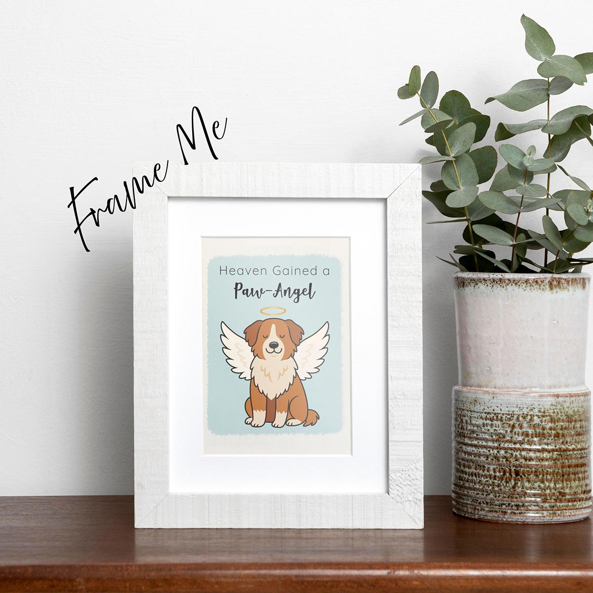 framed Heaven Gained a Paw-Angel pet sympathy card featuring a brown and white dog sitting up facing forward with angel wings and a golden halo on a soft blue background, text on top of card reads "Heaven Gained a Paw-Angel"