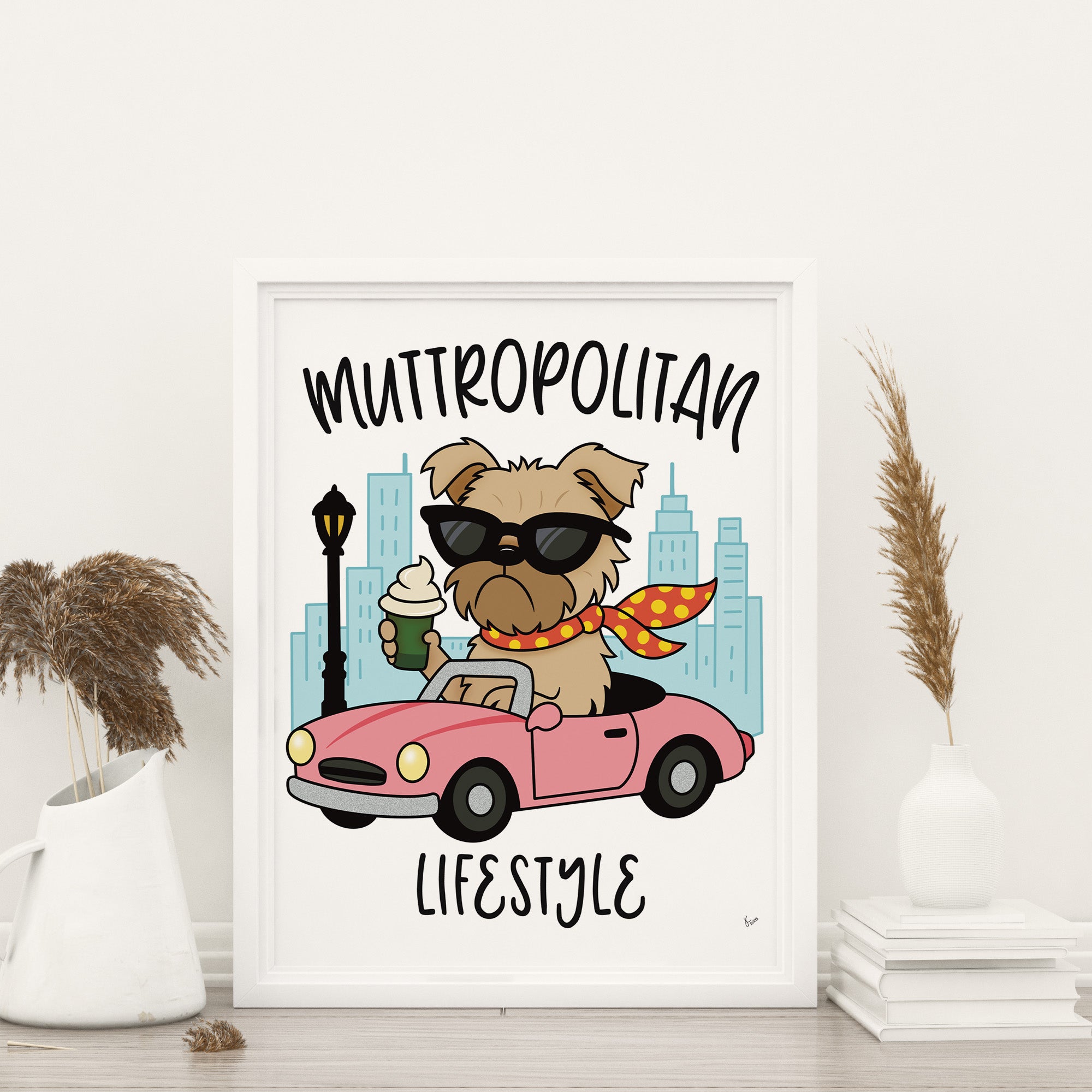 Framed Muttropolitan Lifestyle art print featuring a tan Brussels Griffon dog wearing black sunglasses and a red and yellow polk-a-dot scarf blowing in the wind, holding a puppucino in a green coffee cup and driving a pink convertible car with city high rise buildings and black light post in the background, the words muttropolitan are rounded on top the image and lifestyle is on the bottom, overall image has a white background