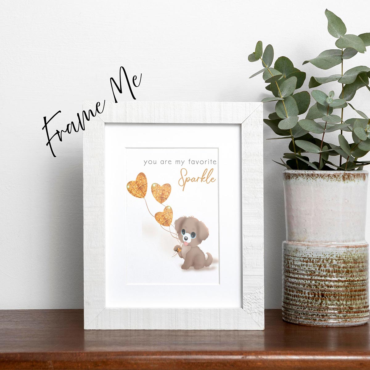 framed "You Are My Favorite Sparkle" greeting card featuring a cute brown puppy holding 3 glittery gold heart-shaped  balloons, black text in simple font at top of card says "you are my favorite" then right below this text still at top of card is gold text in cursive says "Sparkle", the card has a white background, frame is not included in purchase