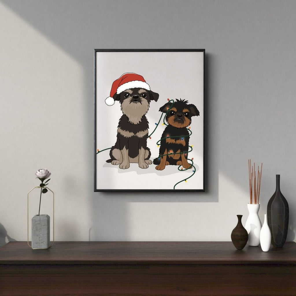 Framed custom hand-drawn artwork of two Brussels Griffons dogs, one wearing a Santa hat, on a wall above a wooden shelf with decorative items.