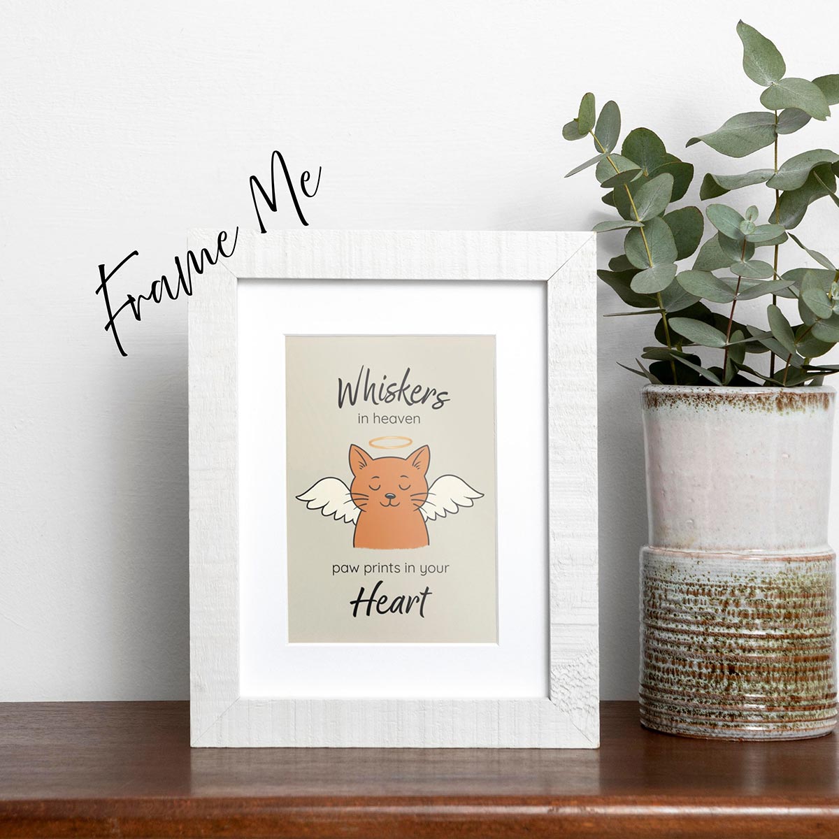 framed Whiskers in Heaven pet loss sympathy card featuring an orange cat with angel wings and gold halo, text reads Whiskers in heaven at top of card and paw prints in your heart at bottom of card, card has a muted light brown background, frame not included in purchase