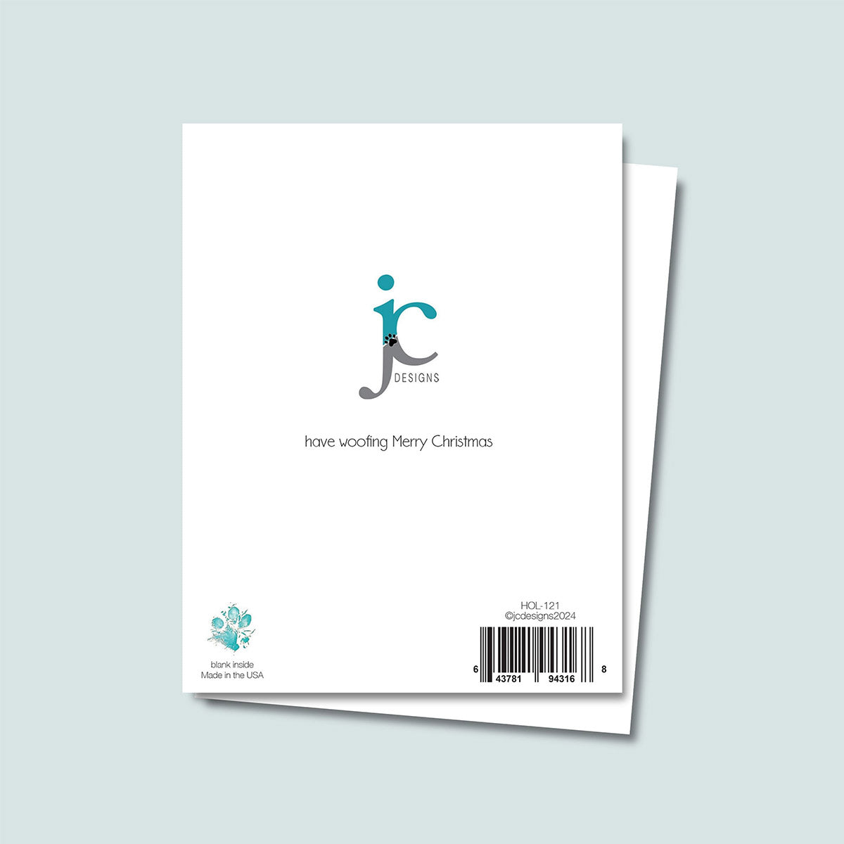 back of We Woof You a Merry Christmas card showing JC Pet Designs logo and a unique tagline message "have a woofing Merry Christmas", Oz's paw print in teal is in bottom left corner right above words "blank inside, made in the USA" and sku and barcode on bottom right corner