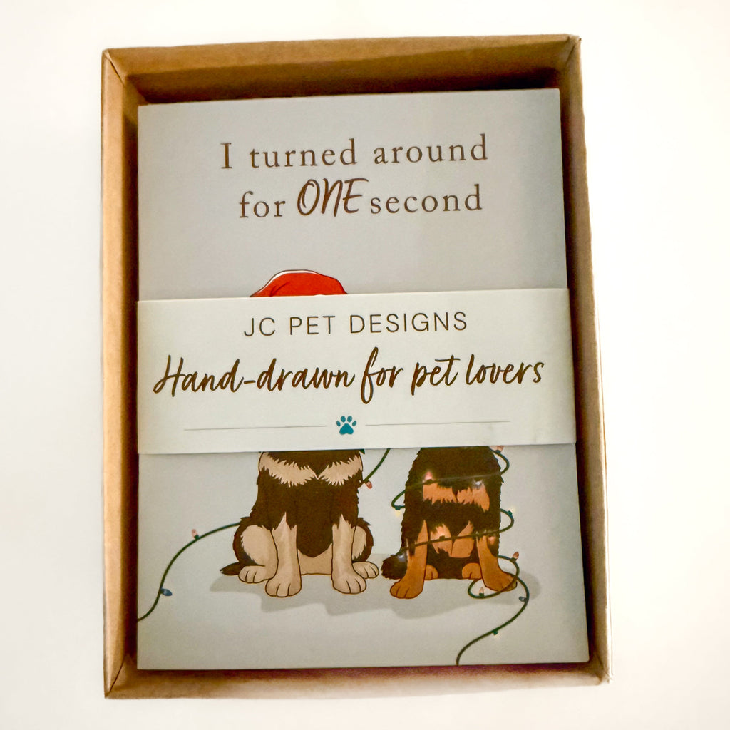 Packaged box of hand-drawn greeting cards from JC Pet Designs with illustrations of dogs and text.