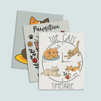 set of three cat=themed art prints stacked, featuring on top The Cats' Timetable art print featuring four illustrated cats lounging, stretching, napping, and playing around a clock design, text The Cat's is arched over the top and text Timeable arched under the bottom, the image is on a light tan background