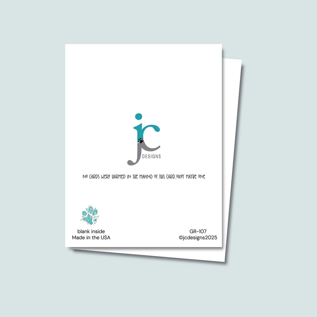 back of The Dog Ate It Birthday card showing JC Pet Designs logo and unique tagline message that reads "No cards were harmed in the making of this card, okay maybe one", in the bottom left corner is Oz's paw print in teal and text "blank inside, made in the USA", the sku and copyright @jcpetdesigns2025 are in the bottom right corner 