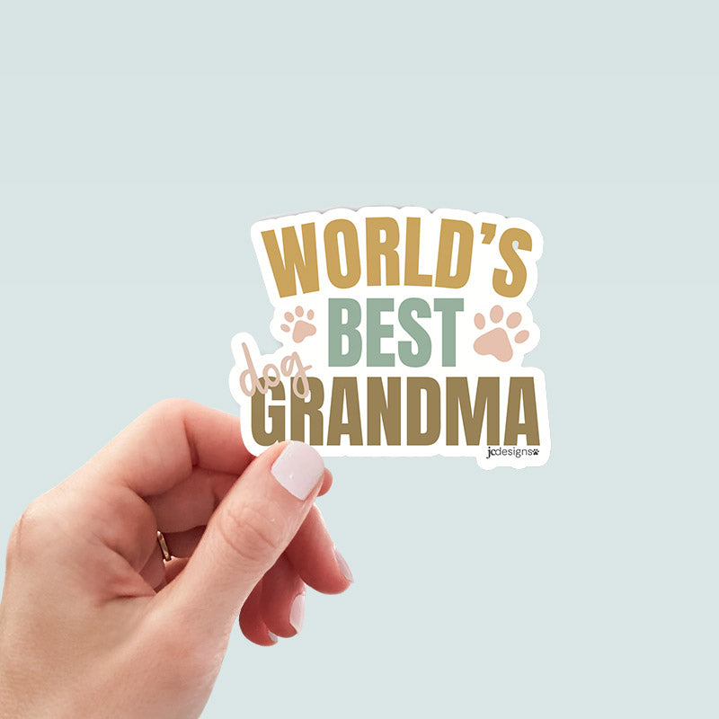 hand holding world’s best dog grandma sticker with playful typography and paw print accents in warm neutral tones