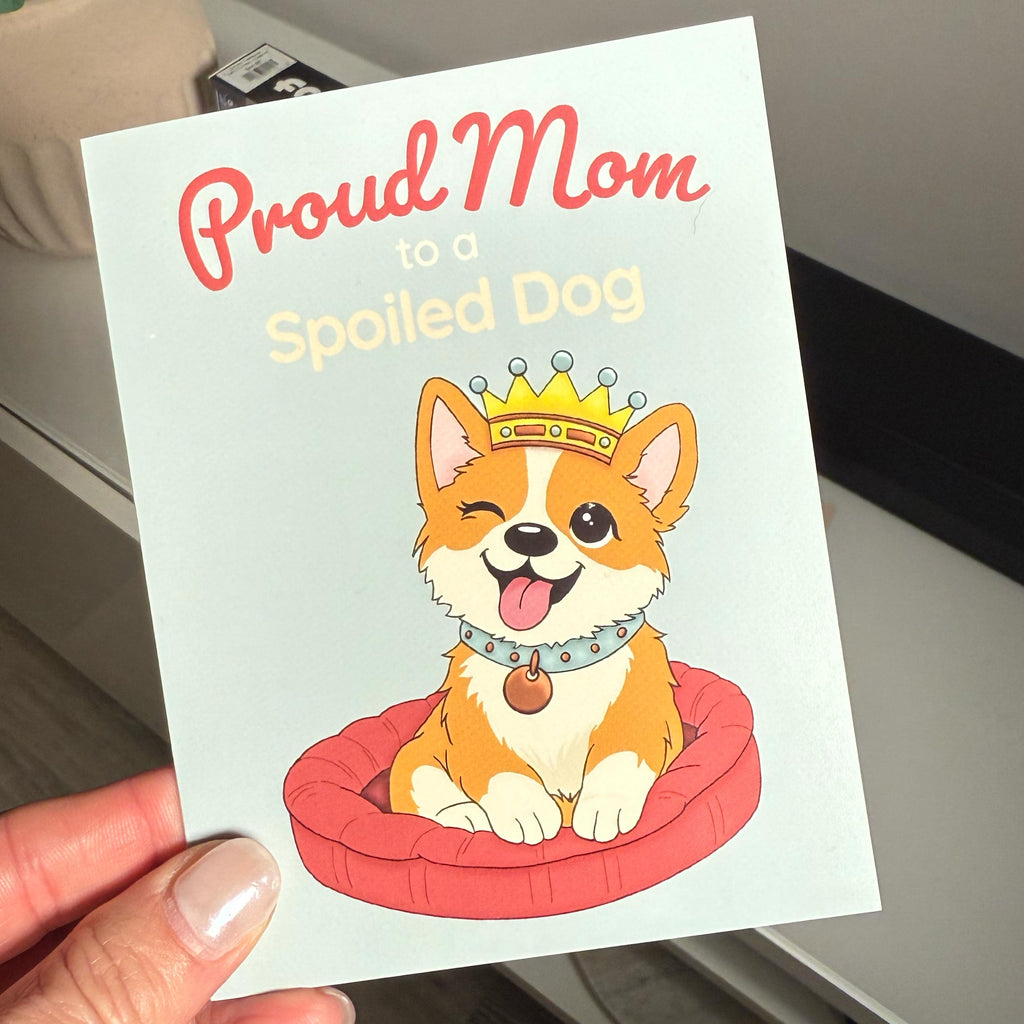 hand holding Illustrated Mother’s Day card showing a happy dog wearing a crown with the text “Proud Mom to a Spoiled Dog”