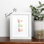 framed Ho Ho Ho Christmas Holiday card featuring red and green letters with gold paw prints in place of the "O" of all 3 Ho Ho Ho's, on a white background, frame not included in purchase