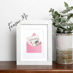 framed I Woof You greeting card featuring a cute Brussels Griffon peaking out of right side of pink envelope with note saying "i woof you" sticking out of envelope, pink hearts around the dog, card has a white background, frame not included in purchase