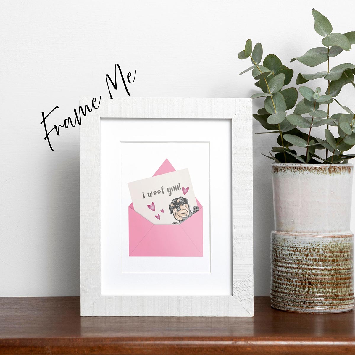 framed I Woof You greeting card featuring a cute Brussels Griffon peaking out of right side of pink envelope with note saying "i woof you" sticking out of envelope, pink hearts around the dog, card has a white background, frame not included in purchase