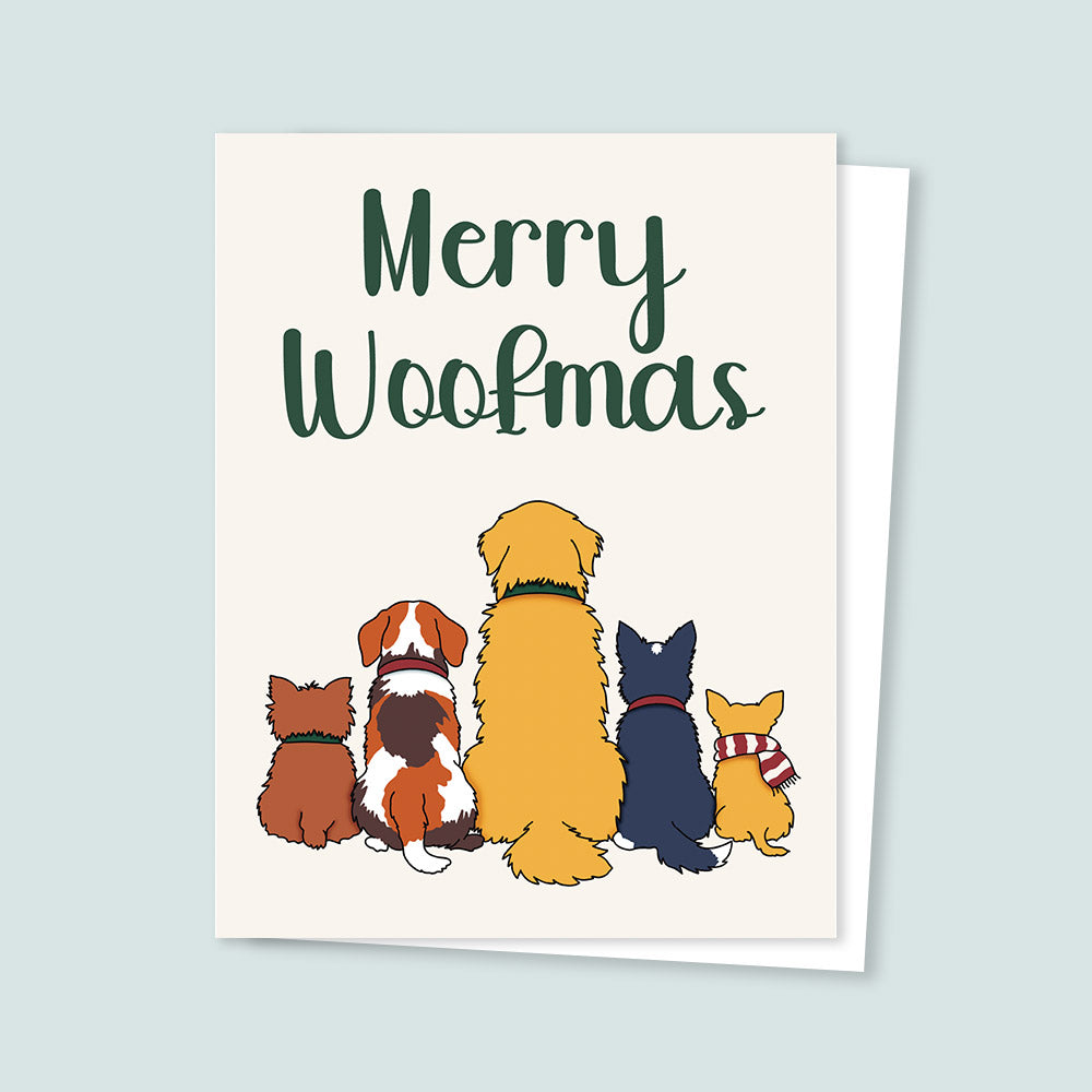Greeting card with cartoon dogs and 'Merry Woofmas' text on a light blue background