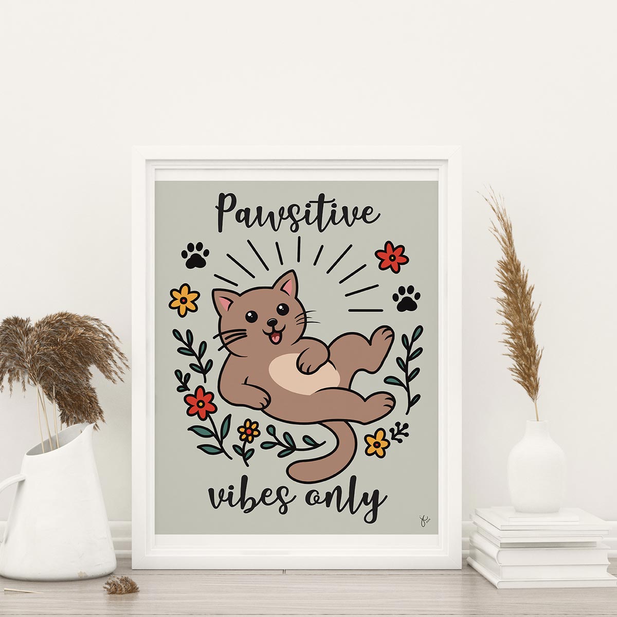 Framed Pawsitive Vibes Only art print featuring happy cartoon brown cat surrounded in a circle of red and yellow flowers and black paw prints with words Pawsitive on top and vibes on bottom print is on a light muted green background, frame is not included with purchase